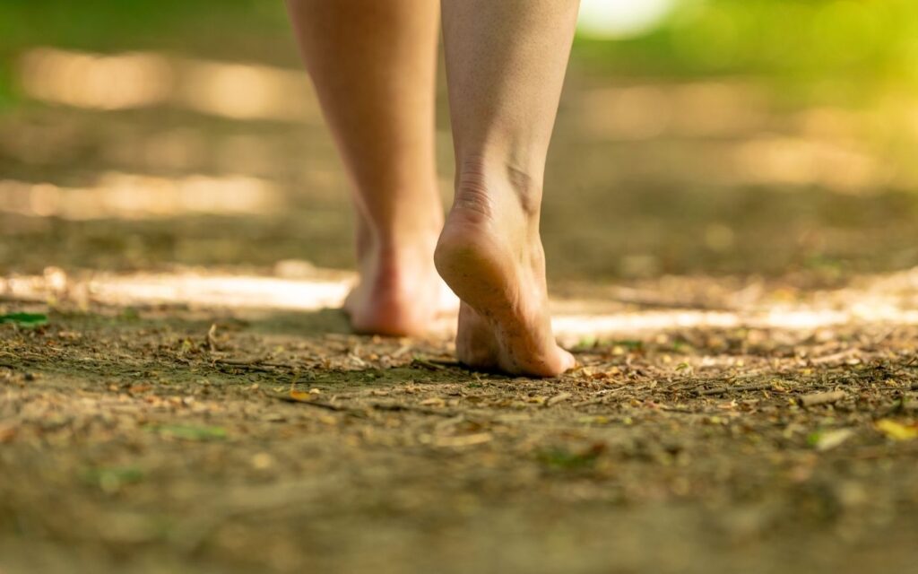 Barfuß gehende Person auf einem Waldweg – Symbol für den eigenen Weg, Umsetzung und Balance bei Hashimoto.