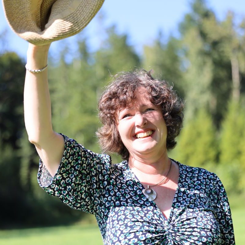 Manuela Glas lacht und hebt den Hut - Begrüßungsfoto zum Energie-Guide