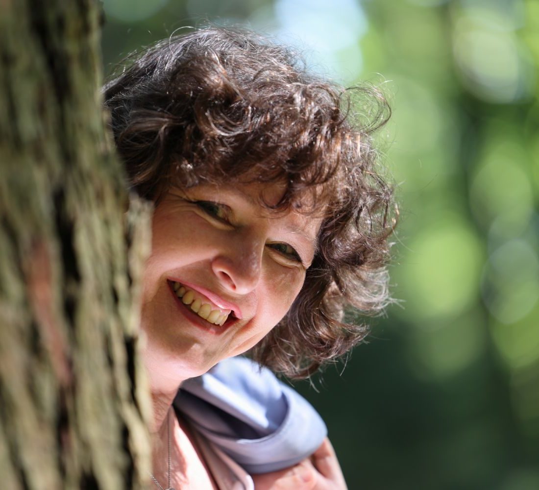 Manuela Glas lächelnd neben einem Baum - persönliche Vorstellung auf der Über-mich-Seite
