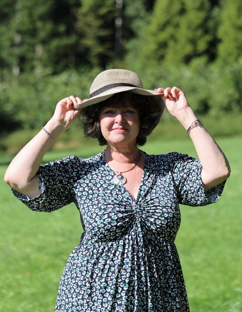Manuela Glas mit Hut auf einer Wiese - Einladung zum Kennenlernen